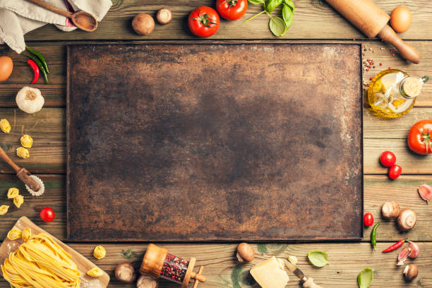 Cooking background: empty rustic baking sheet and italian ingredients. stock photo