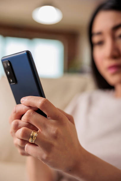 istock Casual happy asian woman using smartphone at home 1420723154