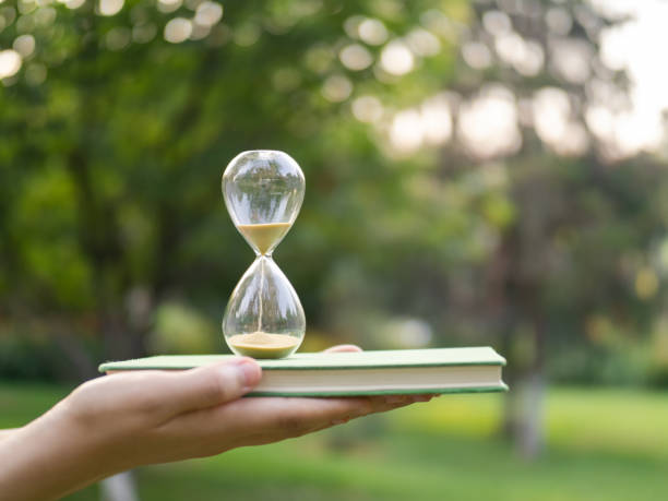 concept de temps et de connaissances - sand clock human hand hourglass photos et images de collection