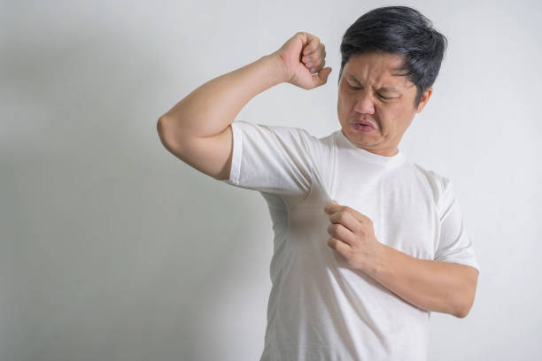 Adult guy held his nose with his hands while feeling the unpleasant smell from underarms. copy space Adult guy held his nose with his hands while feeling the unpleasant smell from underarms. Man raising arm with sweaty armpit at home, copy space body odor stock pictures, royalty-free photos & images