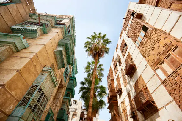 Photo of Traditional residential buildings and palm trees in Al-Balad