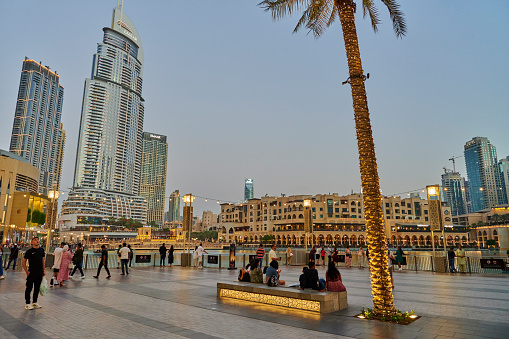 Dubai, United Arab Emirates - May 30, 2022: tourists walking and relaxing at the large terrace outside the Dubai Mall.