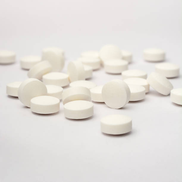 white round pills or tablets scattered on white