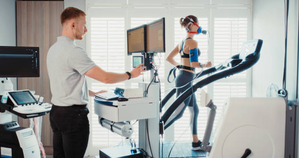 Medical sports doctor doing research on woman athlete, analysis on fitness health and training breathing at sports clinic. Person running on treadmill for science and evaluation on lung at lab stock photo