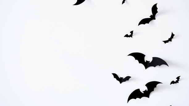 istock Closeup black paper bats on white wall,copy space,decor for holiday.Interior decoration concept for happy halloween,day of the dead celebration.Top view,flat lay. Holiday postcard 1420731762