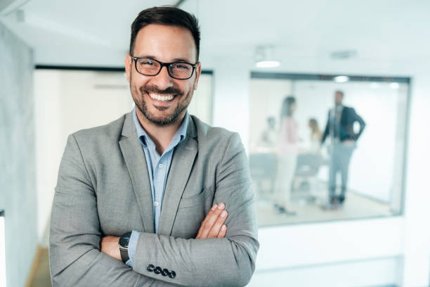 Portrait of businessman Portrait of young businessman at the office, looking at camera and smiling. Cheerful handsome businessman with eyeglasses looking happy eastern european descent stock pictures, royalty-free photos & images