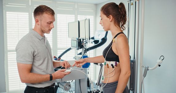 medical doctor digital fitness research, gym science laboratory and physiotherapist monitoring sportswoman physical activity in sports center. Testing athlete healthcare wellness and workout exam