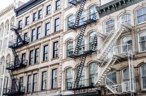 Exterior fire escape staircases on New York City buildings during summer day