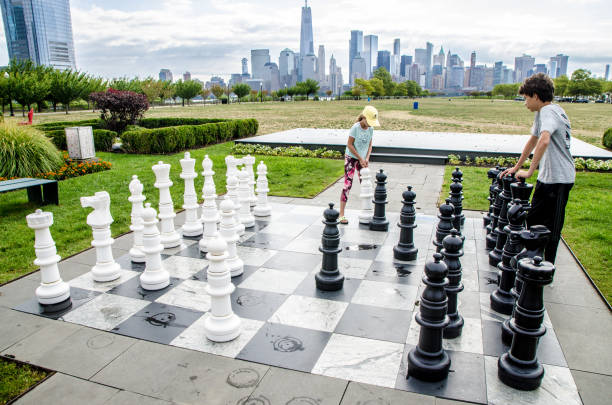istock Two teenagers playing chess outside 1420739807