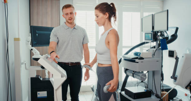 teste de aptidão para uma atleta de alto desempenho em um centro de saúde ou laboratório de ciência do esporte para examinar seu cardio. coach ou fisioterapeuta usando tecnologia para ajudar uma mulher com fisioterapia - clínica de treino desportivo - fotografias e filmes do acervo