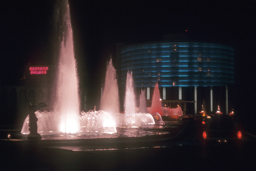 Colourful illuminated waterspout fountain at night