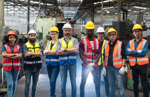 Team Workers and workers are standing in the factory. Group Staff Standing In Engineering Factory. stock photo