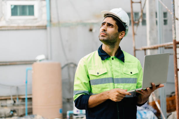 istock Portrait of builder worker in vest with safety hardhat using laptop computer at construction site 1420753561