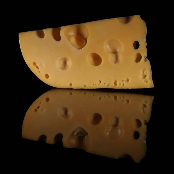 A slice of Swiss cheese on a dark mirrored background.