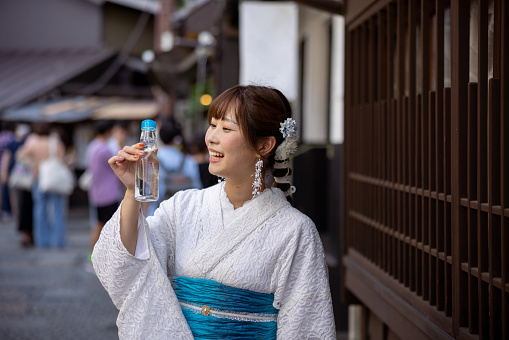 Japanese woman visiting traditional Japanese town. Renting a white lace kimono, eating Japanese food and shopping in retro style Japanese stores, etc.