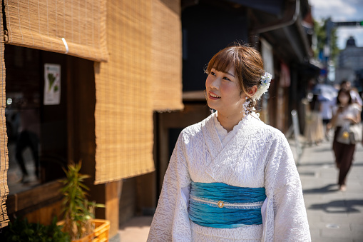 Japanese woman visiting traditional Japanese town. Renting a white lace kimono, eating Japanese food and shopping in retro style Japanese stores, etc.