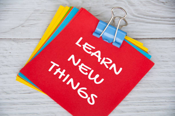 istock Learn new things text on red notepad on white wooden background. Learning concept 1420756648
