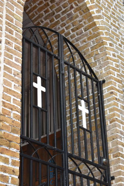 A Close-up, Detailed Shot of a Gate in the Cathedral of the Immaculate Conception in St. George's, Grenada St. George's, Grenada - August 23, 2022 - A Close-up, Detailed Shot of a Black Gate with 2 White Crosses in the Cathedral of the Immaculate Conception, a Roman Catholic Church on Church Street in St. George's, the Capital City of Grenada. The construction of the church was completed in 1884 and is a reflection of Grenada's colonial history with Europe. Due to damages caused by Hurricane Ivan in 2004, parts of the church had to be rebuilt hurricane ivan stock pictures, royalty-free photos & images