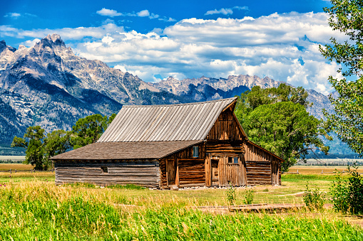 The Moulton Barn, a publicly owned national landmark along the Mormon Row Historic District in Grand Teton National Park, Wyoming with the peaks of the Teton Range in the background.