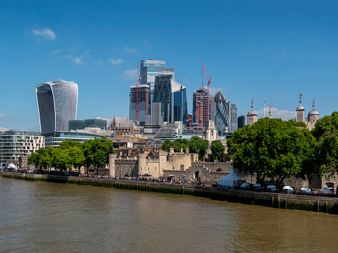 The Tower of London and part of the City of London seen from Tower Bridge on a sunny summer day. (Incidental people.)