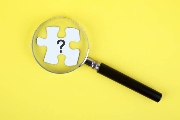 istock Looking at question mark puzzle with magnifying glass 1420771988