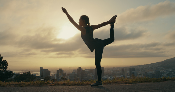 Zen, meditation and yoga with silhouette of woman exercise at sunrise, routine posture and balance training. Flexible female workout, inner peace, energy control and position against city background