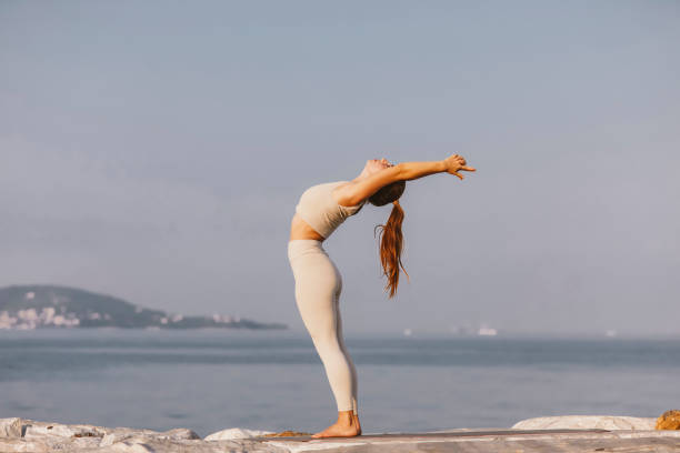 istock young lady doing yoga at seaside 1420776433