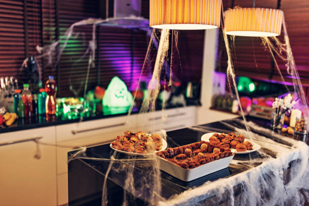 Kids decorating home for the Halloween party. Decorated kitchen with Halloween cakes including \
