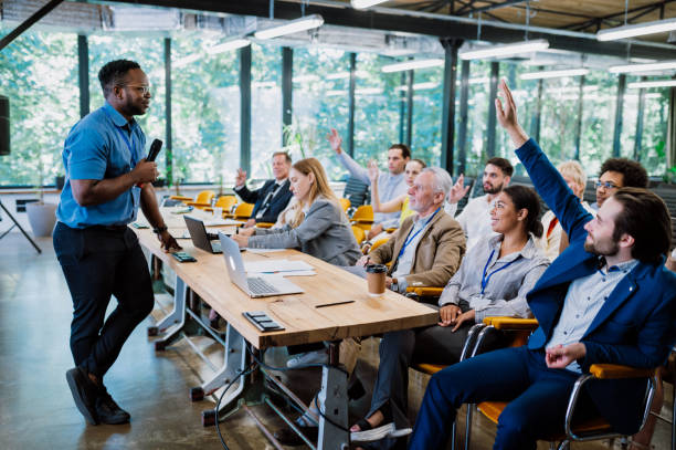 Cinematic image of a conference meeting. Business people sitting in a room listening to the motivator coach. Representation of a Self growth and improvement special event