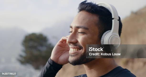 Man On Walk In Nature While Listening To Music On The Radio Or Podcast With Wireless Headphones Fit Active And Healthy Runner On A Wellness Sports And Mental Health Run For Fitness And Exercise Stock Photo - Download Image Now