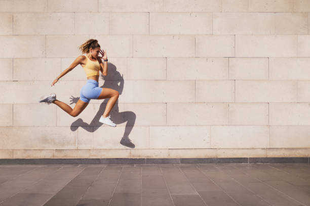 istock Jumped woman with a shadow on a wall background. 1420783488