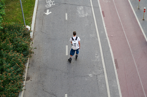 Man is inline skating on cycling road. Concept of active lifestyle. Top aerial view.