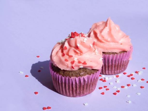 istock Cupcake with a lush pink cream cap on purple, with a place for text 1420787380