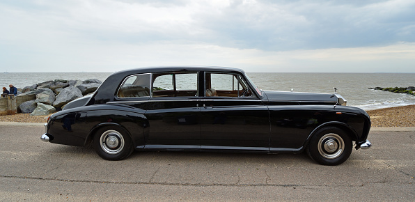 Felixstowe, Suffolk, England - May 01, 2022: Vintage Black Rolls Royce Motor  Car Parked on Seafront Promenade.