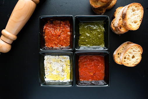 Assoerted Dippings, guacamole dip, dipping sauce, guacamole sauce, chili dip, with bread served in a dish isolated on dark background top view of italian food