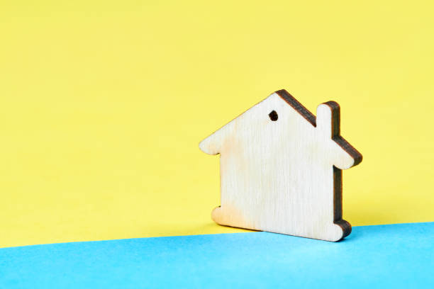 istock Wooden house on the yellow-blue background 1420791414