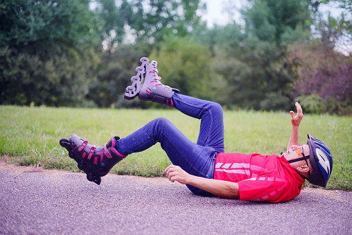 A man rollerblading has fallen on his back.