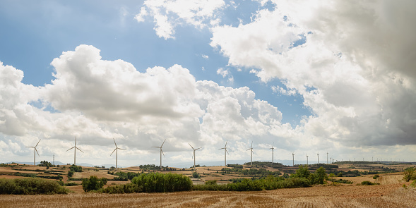 panorama of wind turbines farm field on a cloudy day. High quality photo