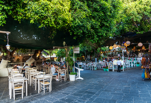 Rhodes Island, Greece - May 25, 2022: The street with restaurants next to each other in the old town area of Rhodes island, Greece.