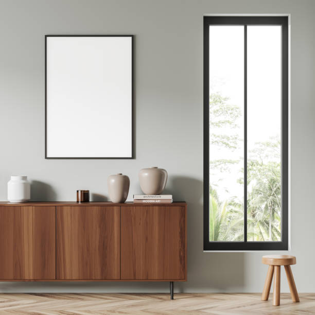 istock Light living room interior with wooden drawer, window and mockup frame 1420799337