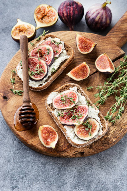 istock Toasts with cream cheese, figs and honey on the table, top view 1420799956