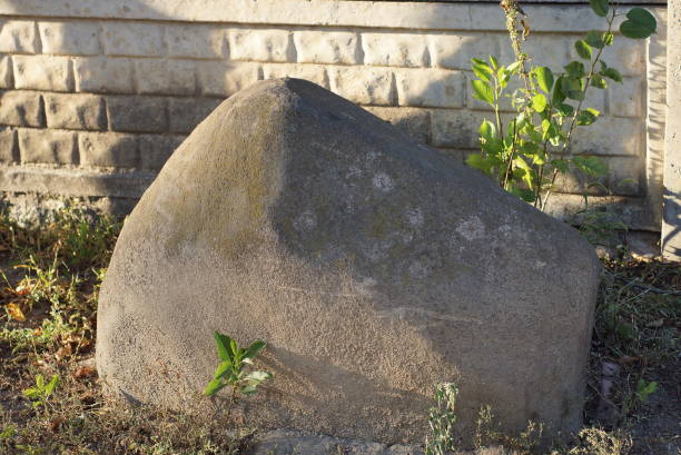 istock one large gray stone stands on the ground and green grass 1420800297
