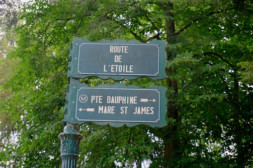 Paris, France - May 29, 2022: Signage in Bois de Boulogne indicating Route de L'Etoile and way to Port Dauphine metro station and Mare St James
