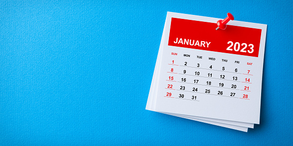 White Sticky Note With 2023 January Calendar And Red Push Pin On Blue Background