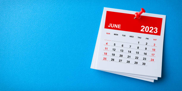 White Sticky Note With 2023 June Calendar And Red Push Pin On Blue Background stock photo