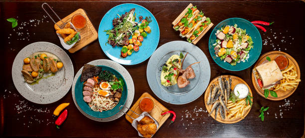 istock Different colorful meals on dark wooden table in the restaurant. 1420809917