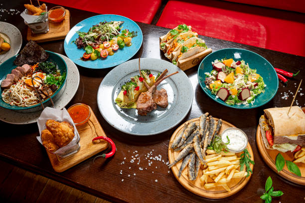 istock Different colorful meals on dark wooden table in the restaurant. 1420809952