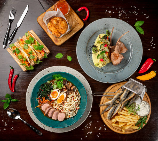 istock Different colorful meals on dark wooden table in the restaurant. 1420810512