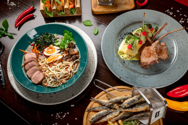 istock Different colorful meals on dark wooden table in the restaurant. 1420810517