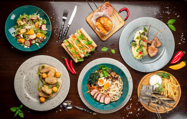 istock Different colorful meals on dark wooden table in the restaurant. 1420810536